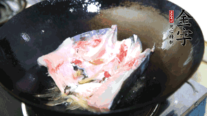 魚頭處理干凈后對(duì)半切開(kāi)，入加熱油的鍋中略煎。