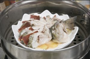 將鱸魚(yú)成花狀擺好，將火腿切片放入各縫隙中，放入鍋中隔水蒸12分鐘拿出，撒上蔥花即可。
