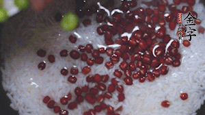 將炒好的食材和大米、紅豆一起放進(jìn)電飯鍋煮。