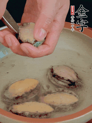 鮑魚加鹽、清水浸泡，用勺子挖出鮑魚肉。