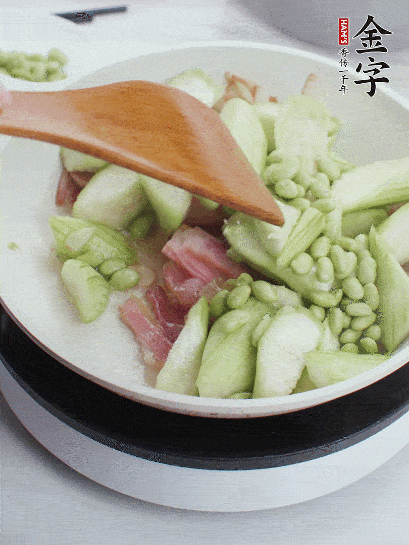 依次下絲瓜、青豆翻炒，炒至絲瓜打蔫縮小。