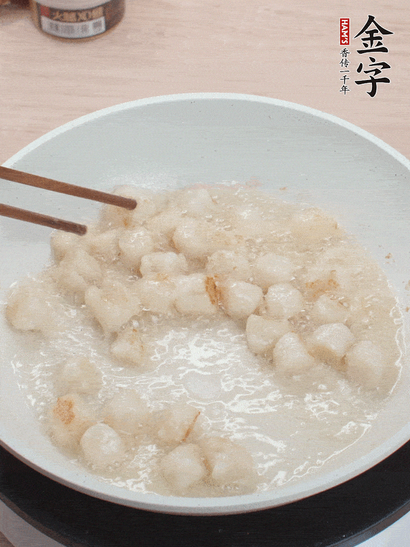 油溫4成熱，鮮貝蘸干淀粉下鍋煎，一面微黃后翻面。
