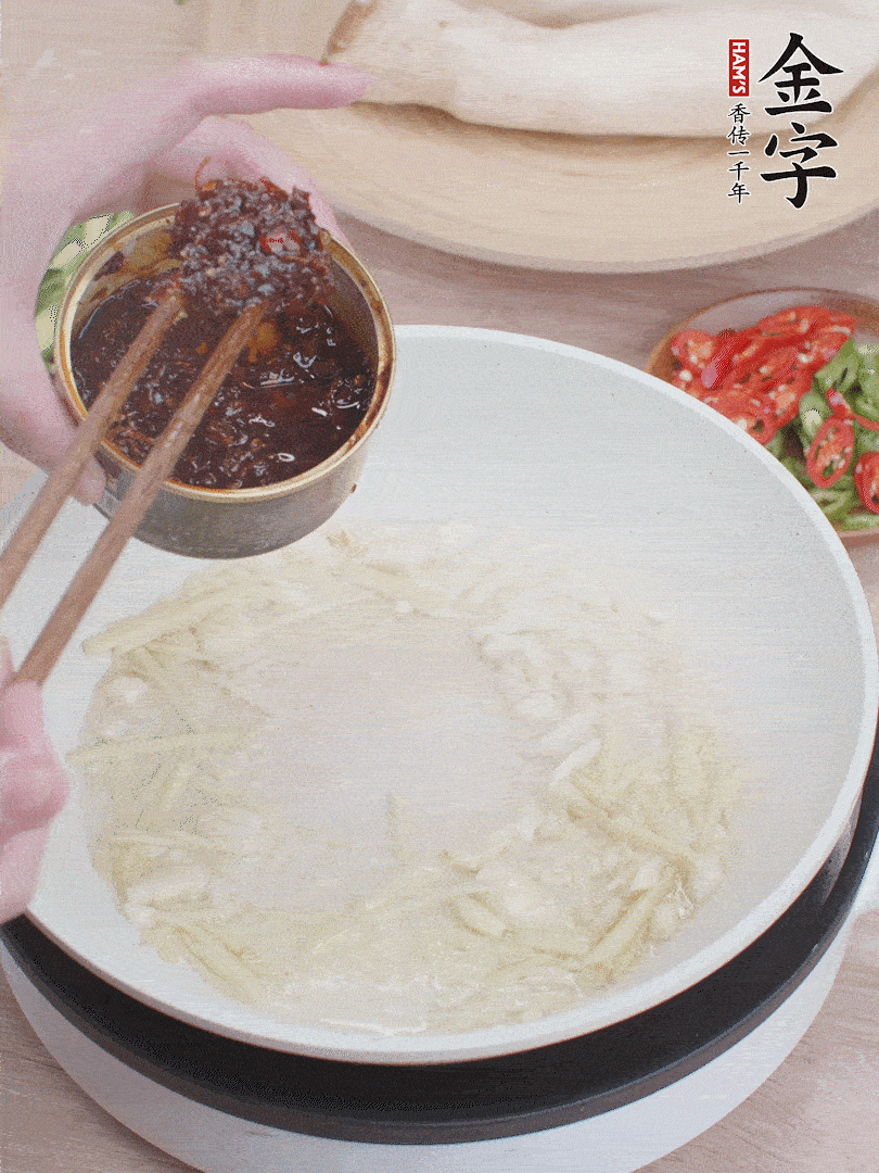 起鍋熱油，姜蒜、金字火腿干貝醬煸香。