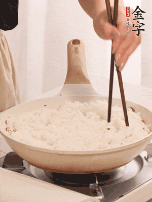 把瀝干水分的米飯均勻鋪在上面，筷子戳幾個洞，以便透氣，轉(zhuǎn)小火蓋上蓋子燜至水分收干，大概10分鐘。